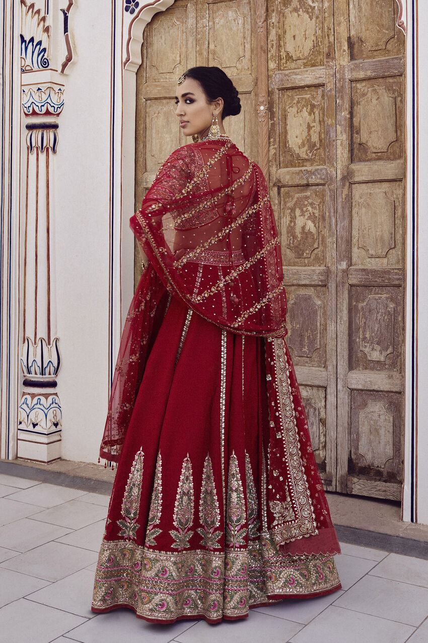 red and white indian wedding dresses Bride in Red-and-Gold Lehenga Embracing Groom in White Sherwani, Turban in Tropical Courtyard